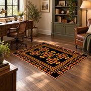 Black and orange tribal area rug with bold geometric border motifs, soft surface detail