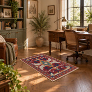 Red and blue ornate floral area rug with cream and teal scroll motifs, complete product view