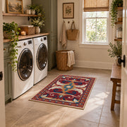 Red and blue ornate floral area rug with cream and teal scroll motifs, wide interior view
