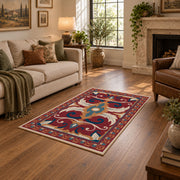 Red and blue ornate floral area rug with cream and teal scroll motifs, design detail view