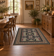 Gray and brown Southwestern area rug with black tribal geometric motifs, featured room view