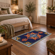 Navy and orange tribal area rug with red and cream geometric details, cozy home setting