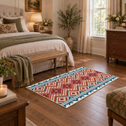 Red and cream diamond area rug with blue and black Southwestern details, cozy home setting