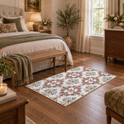 Cream and red floral vine area rug with teal and blue botanical details, cozy home setting